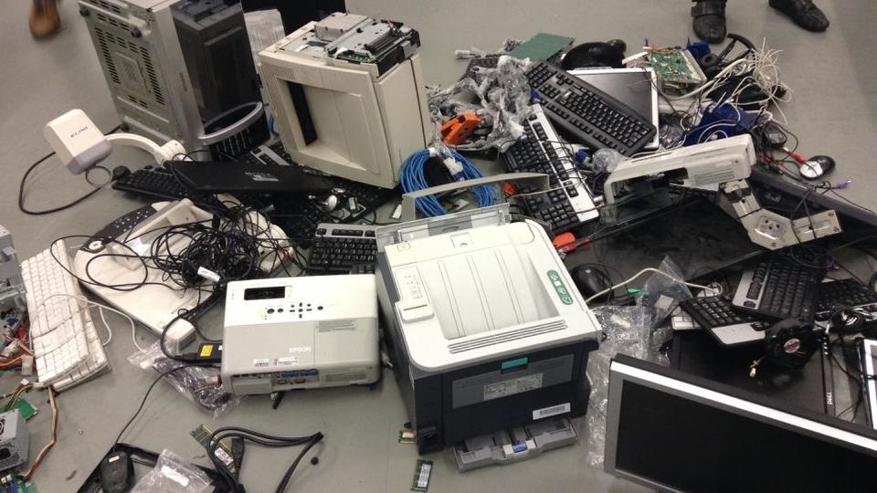 A collection of old IT equipment piled up on the floor