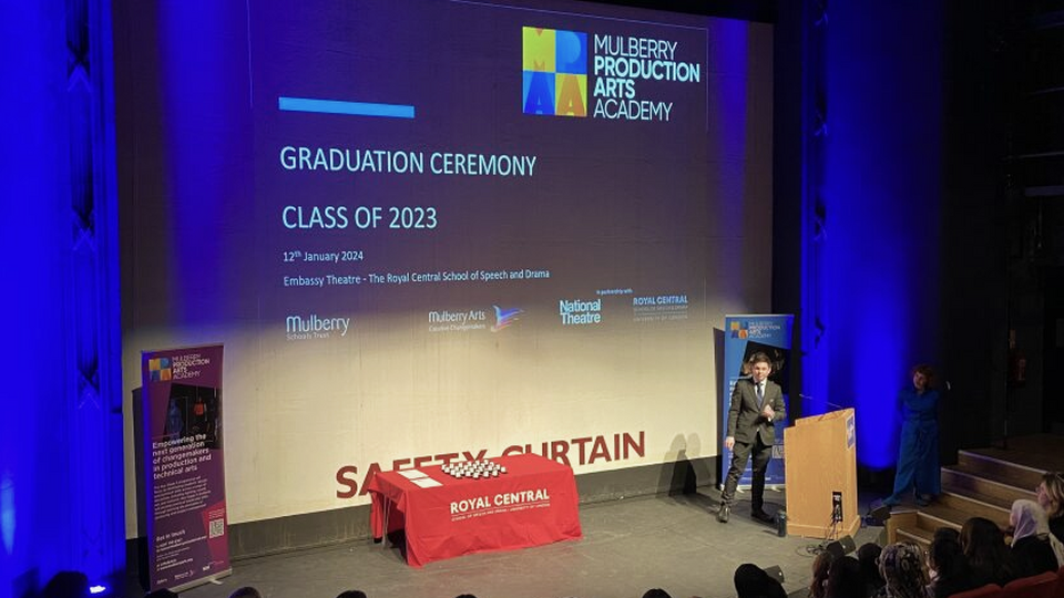 Students from Mulberry Arts sit in Central's Embassy theatre as they are introduced to their graduation ceremony. A presentation plays on the big screen with a welcome slide to the ceremony