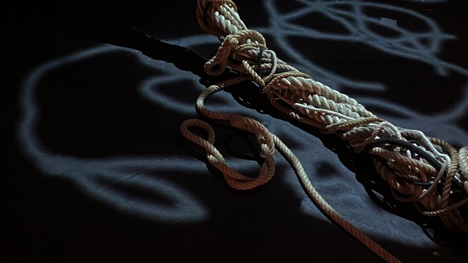 Tangled rope on the floor in shadowy room