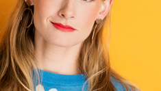 Emma Baker headshot no. 4 (blonde woman wearing blue sweater with daisies)