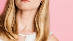 Emma Baker headshot no. 5 (blonde woman in white keyhole top against pink background)