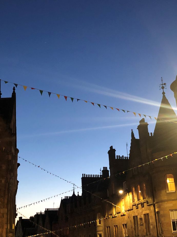 Rooftops of Edinburgh with bunting in front of a twilight sky