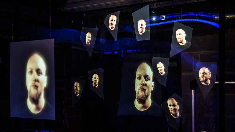 Multiple projections of a face inside a theatre
