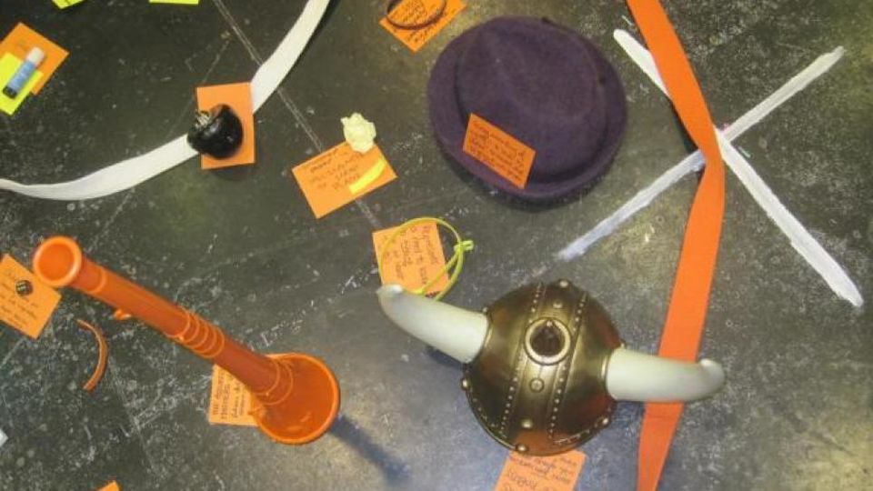 Props on rehearsal room floor marked with notes