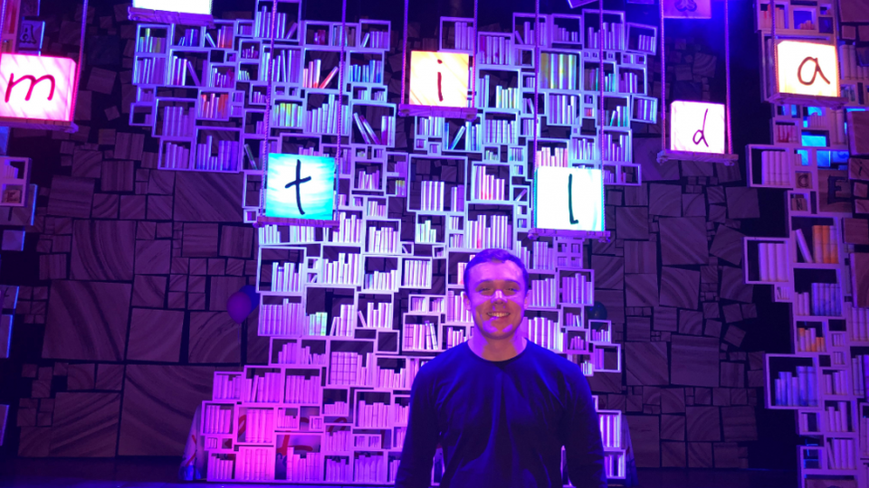 Christian Clark standing in front of the stage for Matilda