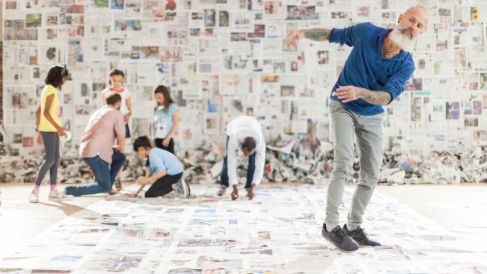 Man and children dancing on newspapers