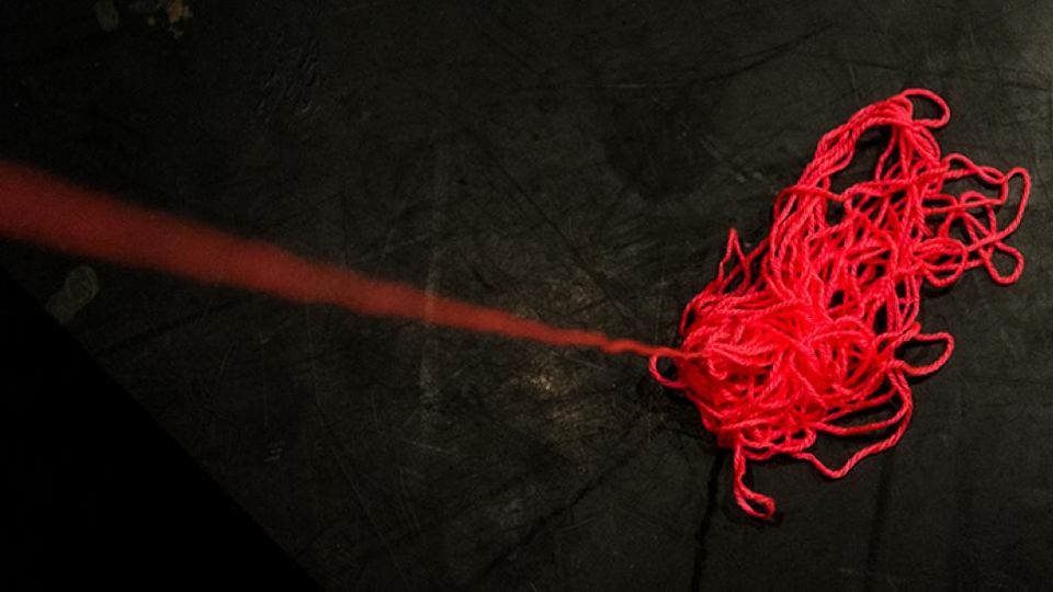A red piece of string on a dark background