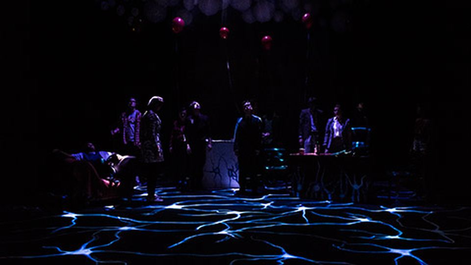 Students performing under coloured lighting design