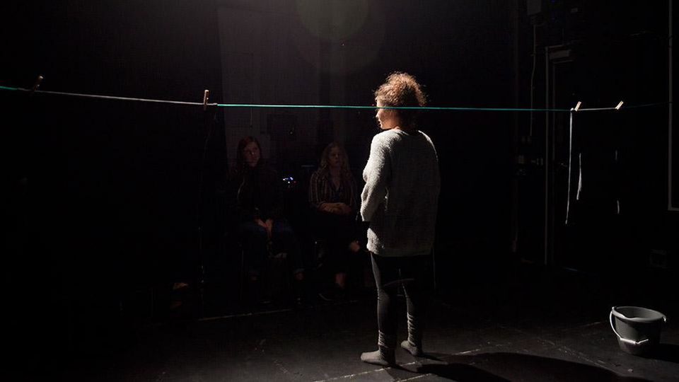 Student performing in black box theatre to audience