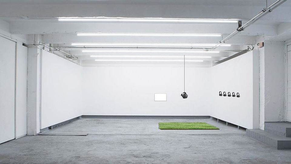 An interior of a large white art gallery space