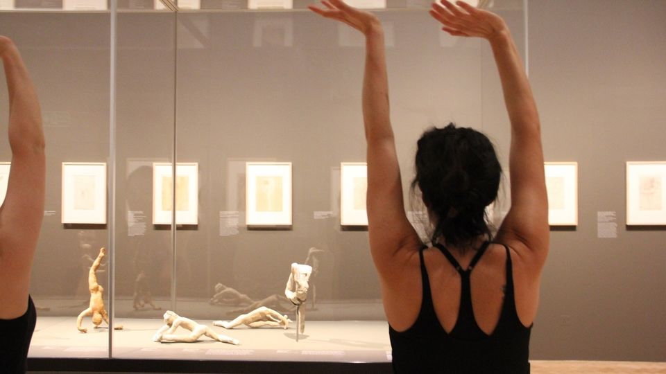 People responding to Rodin sculptures in art gallery