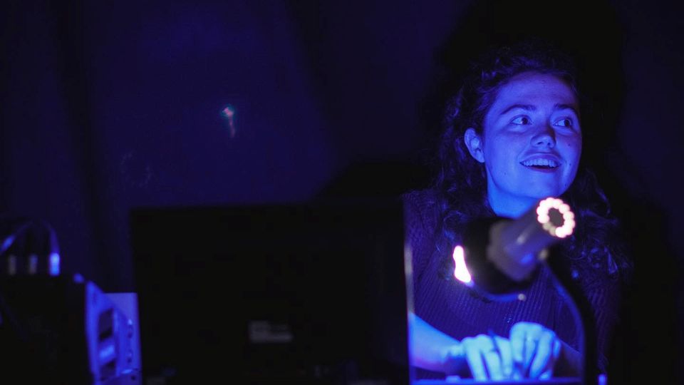A person working at a computer in a blue lit room