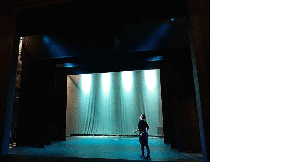 Image of an actor standing on an empty stage 
