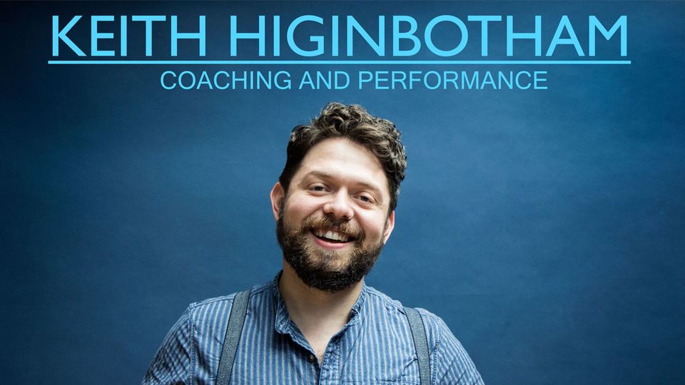Photo of Keith Higinbotham smiling to camera. He is standing against a blue background and the words 'Keith Higinbotham Coaching and Performance' above him