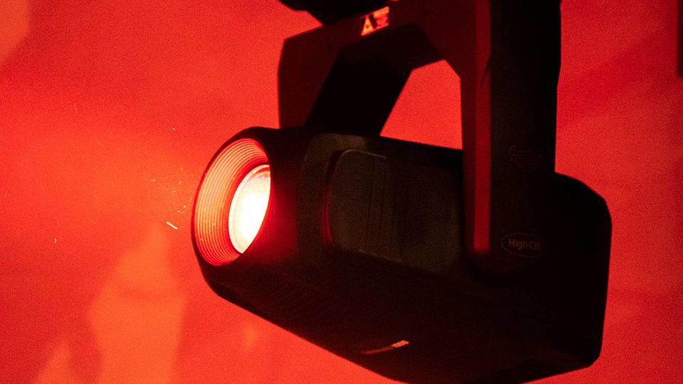 A stage light shining against a red background