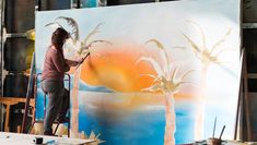 Scenic Art student painting sunset backdrop for a production of musical 'Grease'