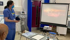 Patient engaging with projection screen and tablet.