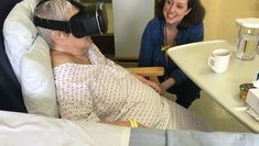 Practitioner smiling at Patient sat in chair in Virtual Reality Headset