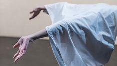 Valerie McCann's arms emerging from a sheet in a backward bending position