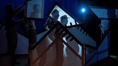 Light shines through set design to show silhouettes of actors