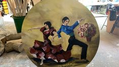 A round painting of two flamenco dancers