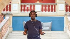 A man wearing headphones in front of staircase