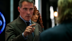 Image of actor Rufus Sewell pointing at a person with their back to the camera in Netflix's Kaleidoscope