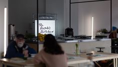 Image showing a glowing white light box sign with the words 'The People's Kitchen' written on it in black lettering