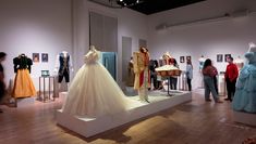 A series of costumes in a gallery by Costume Construction students