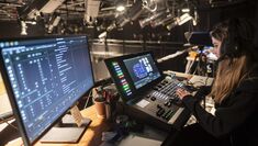 A student uses screens and technology whilst working on a stage production
