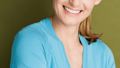 Emma Baker headshot no. 2 (blonde woman smiling in a blue t-shirt)