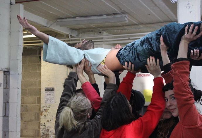 A person being held up in the air on the arms of others