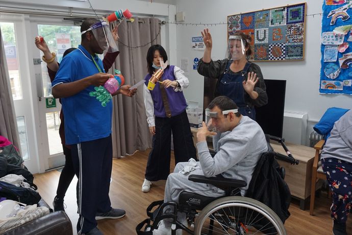 Actors, both standing and in wheelchairs, working on a project