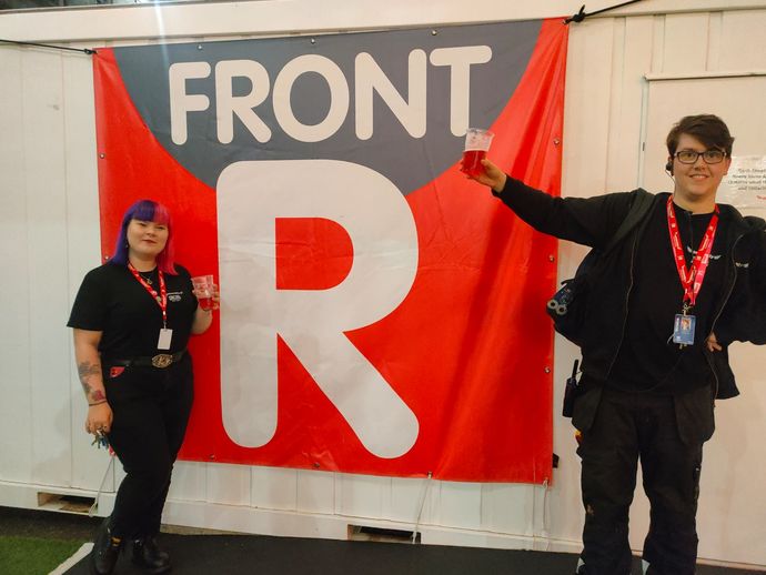 Two people posing in front of a banner
