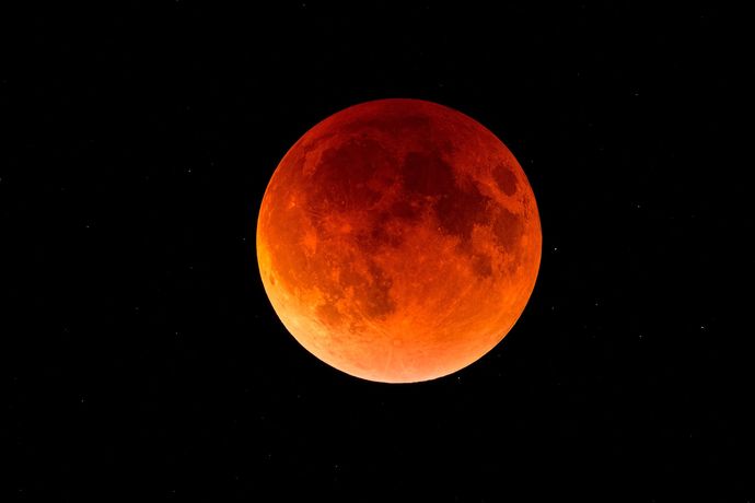 Red full moon against the dark sky.
