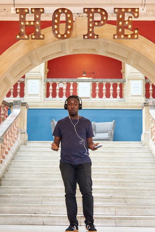 A man wearing headphones in front of staircase